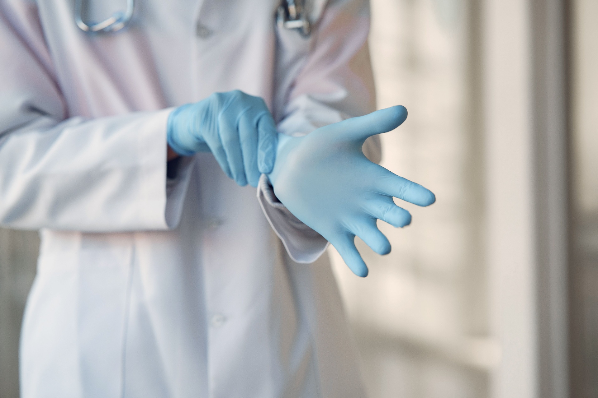 Doctor putting on blue nitrile gloves
