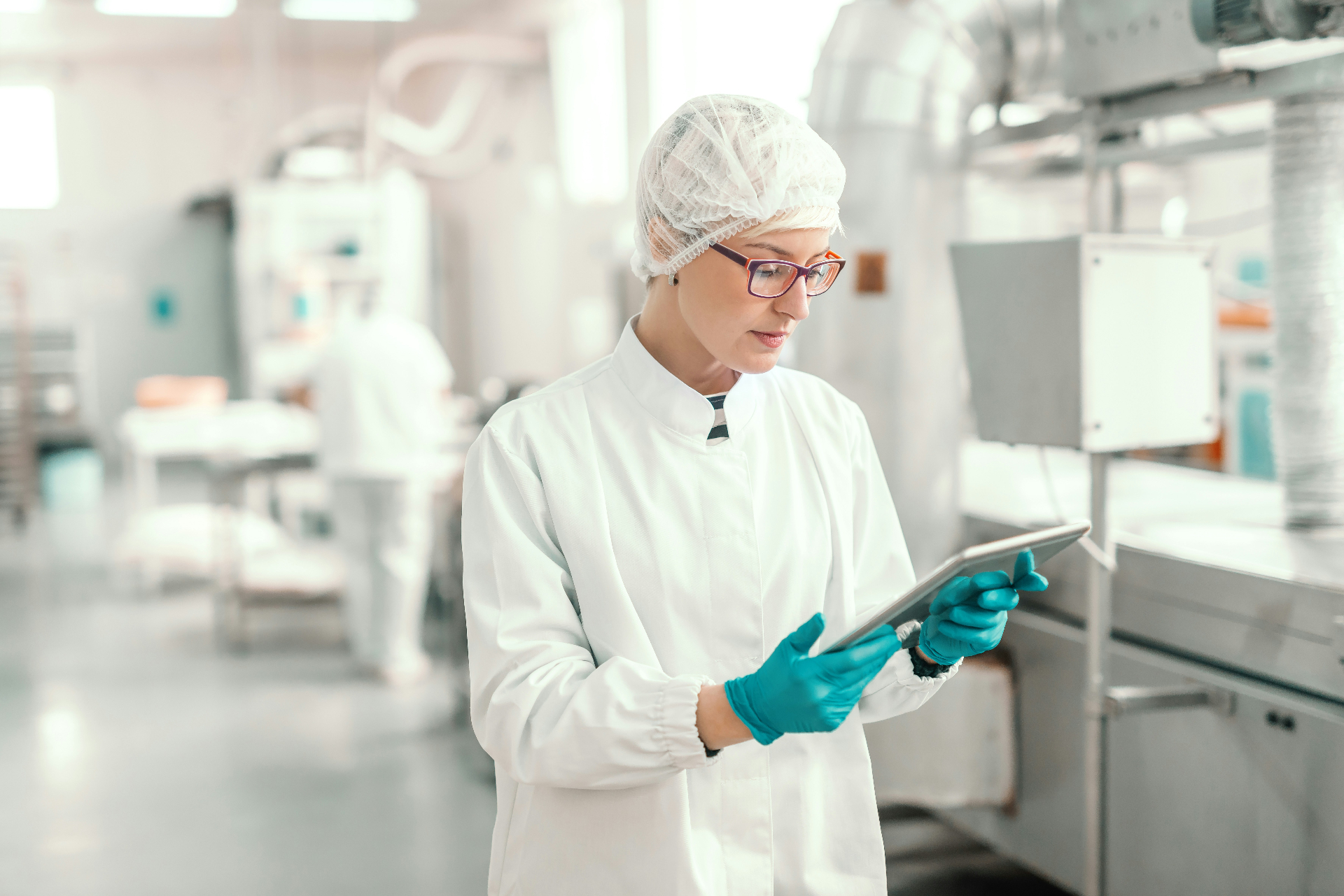 Pharmaceutical worker in cleanroom using a tablet